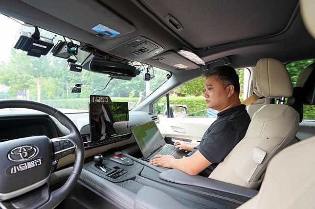 Wang Wei conducts road testing for an autonomous vehicle at an autonomous driving demonstration area in Yizhuang in Beijing, capital of China, June 19, 2024. (Xinhua/Ju Huanzong)