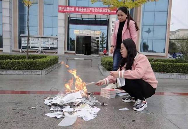 中國甘肅慶陽市鎮原縣立圖書館2名女性人員，在倌前焚嘵清理出來要下架的圖書，引發軒然大波。   圖：翻攝自微博/觀察者網V