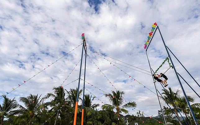 Hongtusi Han Dukai and Gulhayat Mamit &reg; of Xinjiang Uygur Autonomous Region compete in the women's doubles 55kg bell-touching competition of the swing event at China's 12th National Traditional Games of Ethnic Minorities in Sanya, Hainan Province, Nov. 23, 2024. (Xinhua/Cao Yiming)