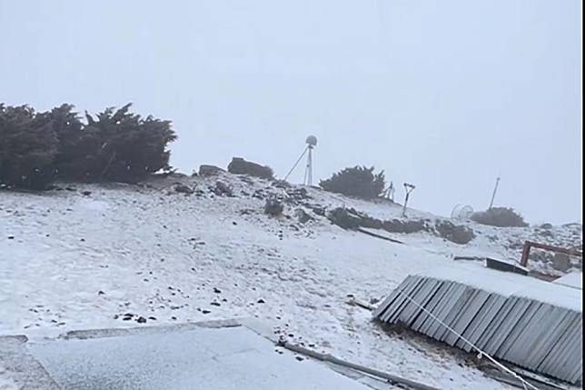 玉山氣象站在今天下午３點 50分開始下雪，地面和屋頂上很快就被染上了白色。（中央氣象署提供）