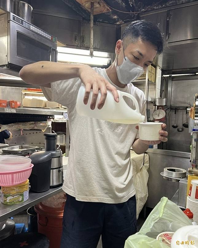 楊皓崴到早餐店兼差打工，在廚房裡熟練倒著飲料。(記者李紹綾攝)
