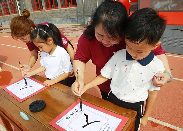 Students write Chinese character &ldquo;Ren&rdquo; at the opening ceremony of the new semester at a primary school in Dongcheng District, Beijing, capital of China, Sept. 1, 2024. (Xinhua/Xu Xiaoxuan)