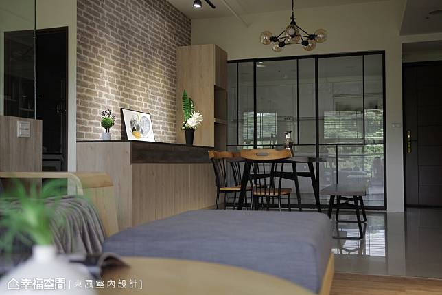 客廳與餐廳利用磁磚及木地板區隔場域，選用鐵件元素鋪陳出俐落的工業性格。