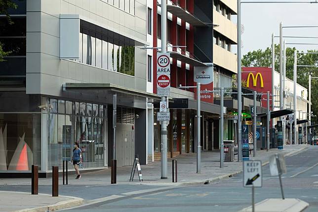(แฟ้มภาพซินหัว : หญิงเดินริมถนนในกรุงแคนเบอร์รา เมืองหลวงของออสเตรเลีย วันที่ 4 ม.ค. 2022)