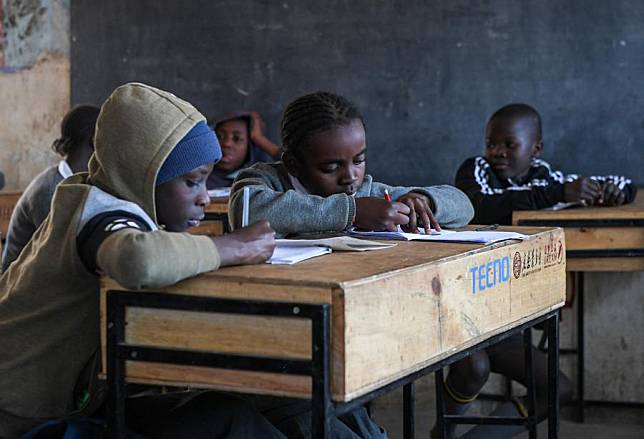 Pupils do their classwork on newly donated desks at a school in Mathare slums in Nairobi, Kenya on Oct. 15, 2024. (Xinhua/Li Yahui)