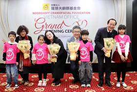 受助兒童獻花給羅慧夫顱顏基金會越南分會顧問王金英(左2)、執行長陳依伶(左4)、駐越南代表劉世忠(右4)、越南中央兒醫院長陳明典(右2)。（中央社）