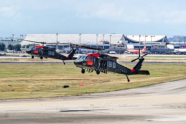 7月19日，國軍實施桃園機場反空降演習預演，扮演敵軍的特戰隊員搭乘黑鷹直升機準備在機場著陸。（攝影／陳曉威） 