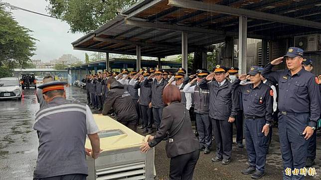 台鐵林姓機車長搭專列回宜蘭，同仁雨中列隊淚崩高喊「任務結束，一路好走」。(記者王峻祺攝)