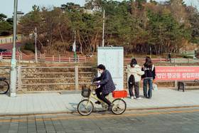南韓老年人示意圖。圖為一名老婦人在水原市街道上騎著自行車。pexels