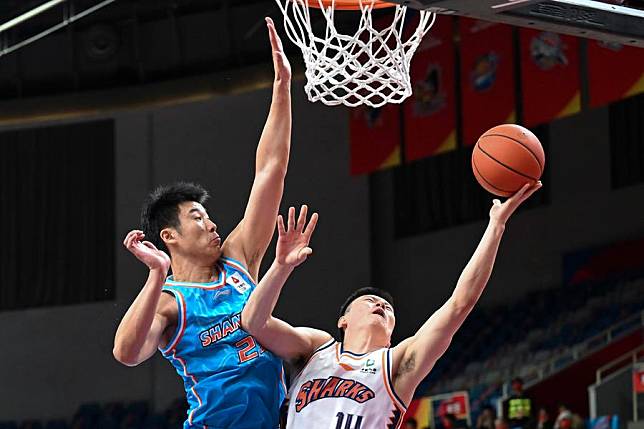 Li Hongquan &reg; of Shanghai Sharks goes for a lay-up under the defense of Jia Cheng of Shandong Heroes during their 7th round match at the 2022-2023 season of the Chinese Basketball Association (CBA) league in Hangzhou, east China's Zhejiang Province, Oct. 25, 2022. (Xinhua/Chen Zhenhai)