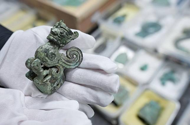 A staff member displays a bronze relic at a research institute of Sanxingdui ruins in Guanghan City, southwest China's Sichuan Province, Dec. 16, 2024. (Xinhua/Jiang Hongjing)