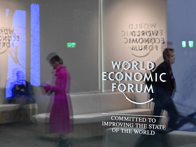 People walk past the logo of the World Economic Forum (WEF) in Davos, Switzerland, Jan. 23, 2025.(Xinhua/Lian Yi)