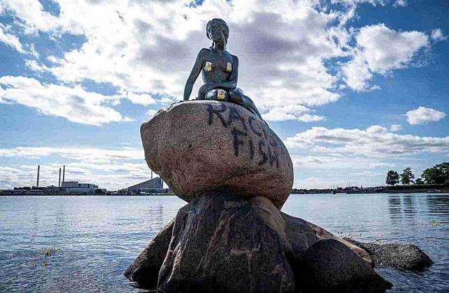 位於丹麥首都哥本哈根的美人魚雕像，當地時間3日遭人噴漆，噴上「種族主義魚」（Racist Fish）等字眼。   圖：翻攝自微信