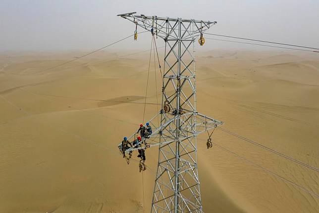 Aerial photo taken on Sept. 28, 2020 shows workers working on a pylon at the Taklimakan Desert in Hotan Prefecture, northwest China's Xinjiang Uygur Autonomous Region. (Xinhua/Hu Huhu)