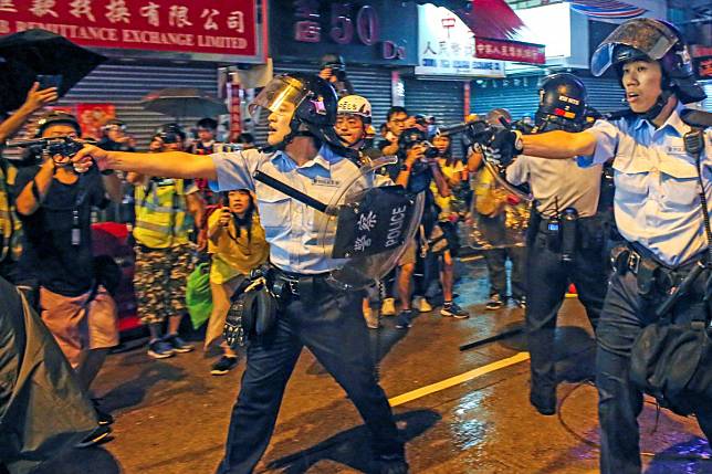 Police officers draw their guns after a clash in Tsuen Wan. Photo: Handout