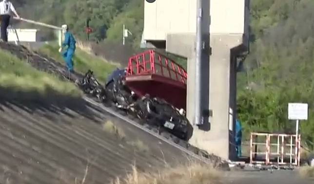日本長野縣24日發生死亡車禍，行駛在堤防道路的BMW轎車失控衝下斜坡，撞上了水門設施。(圖擷自TBS NEWS)