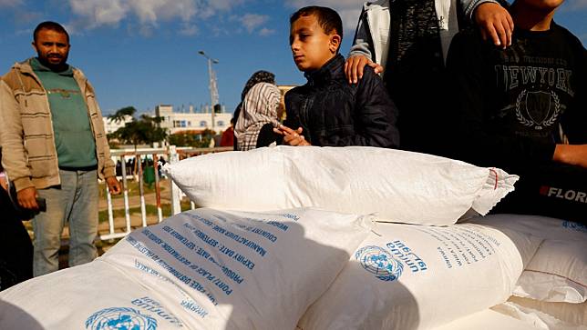巴勒斯坦民眾在加薩南部拉法接受UNRWA提供的麵粉。路透社