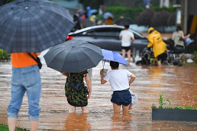 People wades through a waterlogged road in Changsha, central China's Hunan Province, June 24, 2024. (Xinhua/Chen Zeguo)