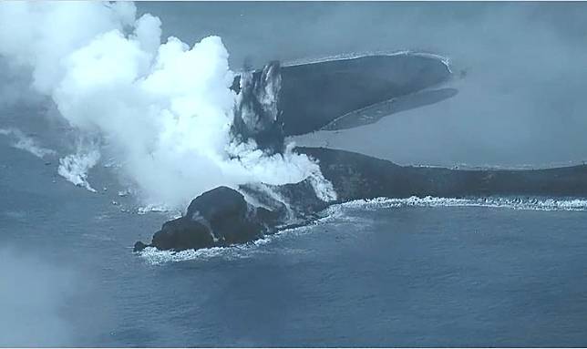 日本小笠原群島硫磺島南部海岸火山噴發冷凝岩石島，遭目擊還在持續噴發中。畫面中白色氣體為「潛水蒸氣噴發」，中間黑色部份則為新的火山灰、岩石碎屑噴發。 圖：翻攝「X」@JCG_koho