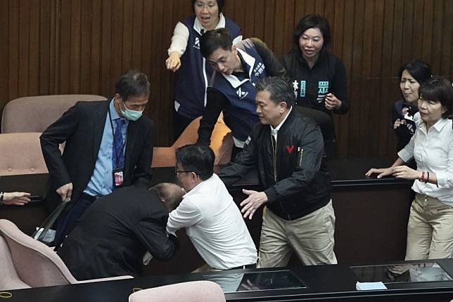 民進黨立委郭國文（前左二）下午突襲主席台不成，改搶立法院秘書長周萬來（前左）手中資料。（中央社）
