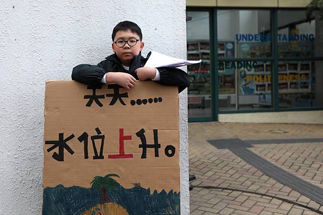 Lance Lau Hin-yi protests outside his school in Hong Kong before class last Friday. Only 10 years old, he is passionate about saving the environment. Photo: Xiaomei Chen