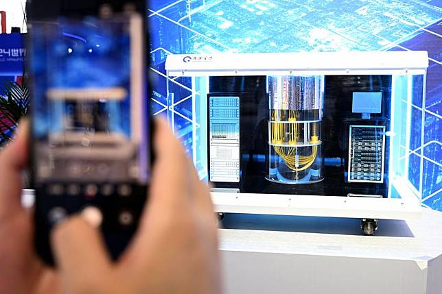 A visitor takes photos of an Origin Wukong superconducting quantum computer model at the 2024 World Manufacturing Convention in Hefei, east China's Anhui Province, Sept. 20, 2024. (Xinhua/Huang Bohan)