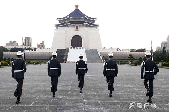 清晨的中正紀念堂空氣冷冽，偶有晨運民眾經過，後方的銅像大廳大門都還未開啟，禮兵完成升旗後折返，為一天揭開序幕。這日復一日的背影，同樣也是國軍盡己之力完成每日各項任務的縮影。（蘇仲泓攝）