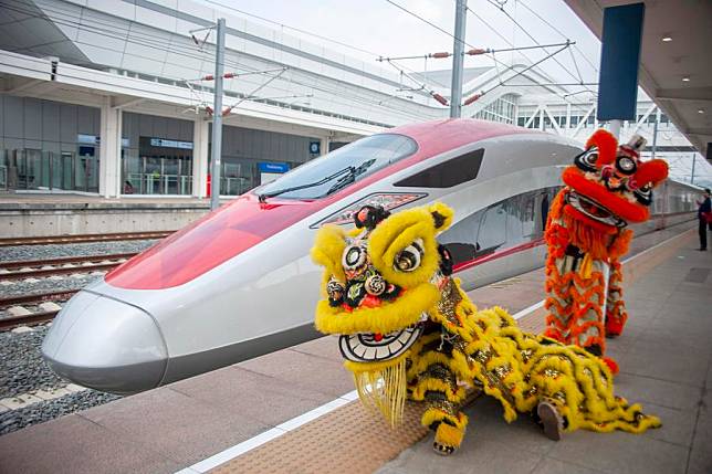 Lion dance performers pose for photos with a high-speed electrical multiple unit (EMU) train on the platform at the Jakarta-Bandung High-Speed Railway's Padalarang Station in Padalarang, Indonesia, Feb. 10, 2024. (Photo by Septianjar Muharam/Xinhua)