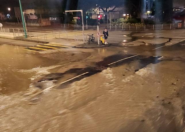 大量黃泥水湧出路面，一名市民舉步維艱。