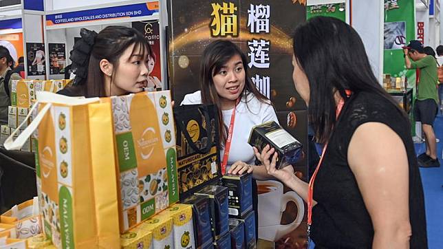 A visitor learns about a durian-flavored coffee at the booth of Malaysia during the 21st China-ASEAN Expo at Nanning International Convention and Exhibition Center in Nanning, south China's Guangxi Zhuang Autonomous Region, Sept. 24, 2024. (Xinhua/Zhang Ailin)