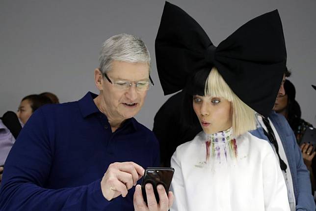 蘋果執行長庫克與模特兒一同把玩iPhone7（美聯社）