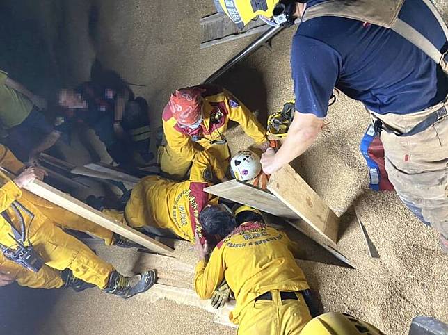 移工掉入麥子堆裡受困，消防隊員全力搶救。(民眾提供)