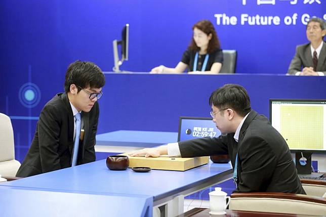 人工智慧軟體AlphaGo與中國棋王柯潔（左）3盤對戰，AlphaGo大獲全勝，右為代表AlphaGo在棋盤上落子、台灣出身的DeepMind研究員黃士傑博士（AP）