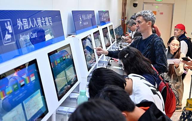 Tourists from Singapore fill in digital arrival cards at the Meilan International Airport in Haikou, south China's Hainan Province, Dec. 28, 2024. (Xinhua/Guo Cheng)