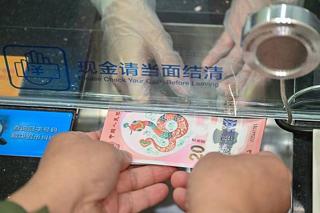 A citizen exchanges commemorative banknotes in celebration of the upcoming Chinese New Year at a branch of China Construction Bank in Beijing, capital of China, Jan. 3, 2025. (Xinhua/Li Xin)