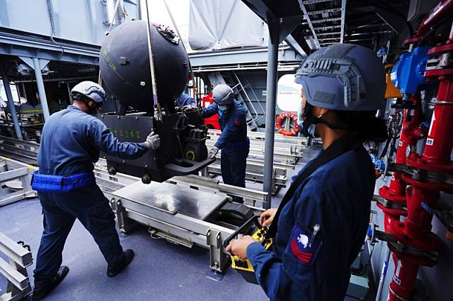 官兵將水雷自岸上吊掛進快速布雷艇艇身中段作業區，並放置在該區的布雷軌道上。（取自中華民國海軍臉書）