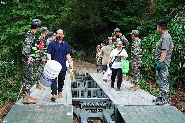 Villagers walk on a temporary bridge built by the armed police force in Xiaoxi Village of Shaolian Township in Shexian County, east China's Anhui Province, June 22, 2024. (Xinhua/Du Yu)