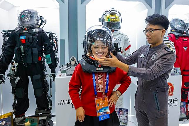 A visitor tries a space helmet originating from “The Wandering Earth”, a Chinese sci-fi blockbuster, during the 81st World Science Fiction Convention (WorldCon) in Chengdu, southwest China's Sichuan Province, Oct. 18, 2023. (Xinhua/Shen Bohan)