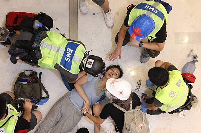 An injured woman is treated at a shopping mall in Sha Tin on Sunday during clashes between extradition bill protesters and police. Photo: EPA