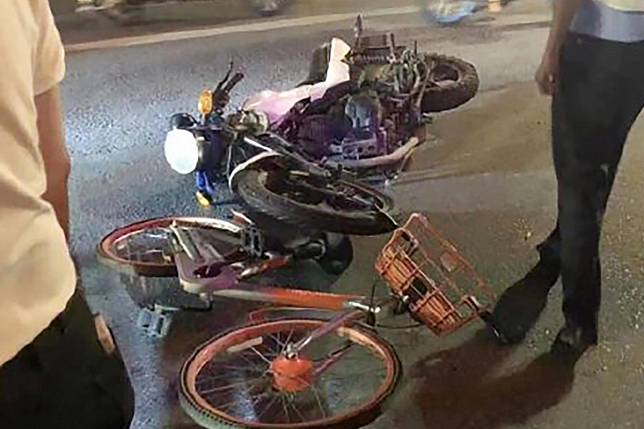 An auxiliary traffic officer threw a bike into the path of a motorcyclist to stop the rider and his passenger from fleeing a random breath test stop. Photo: Weibo