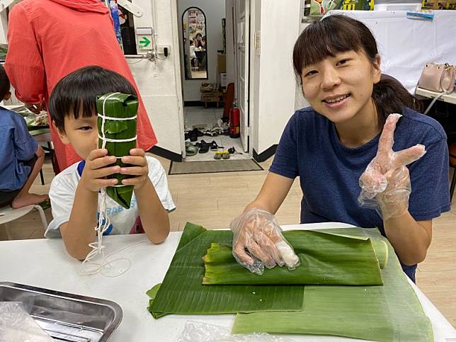 日本新住民小緒里和兒子一起包粽子。（圖／移民署嘉義市服務站提供）
