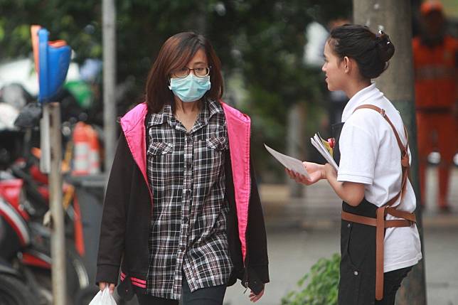 A woman wearing a protective mask walks past a shopping centre in Jakarta, Indonesia. Photo: EPA-EFE