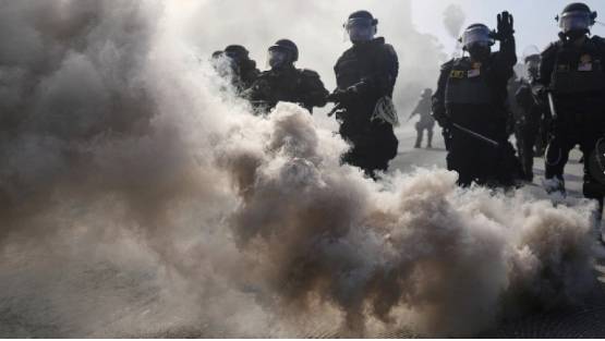美國加州洛杉磯陷入非法移民爆亂，鎮暴警察釋放催淚瓦斯。 圖 : 翻攝自騰訊網