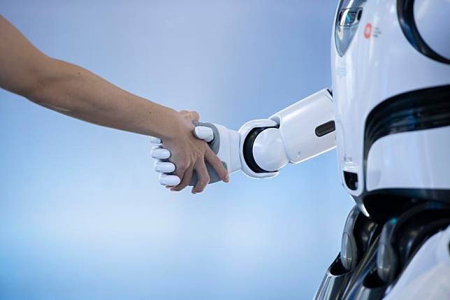 A staff member shakes hands with a robot at a sci-tech company in Shenzhen, south China's Guangdong Province, June 26, 2024. (Xinhua/Mao Siqian)