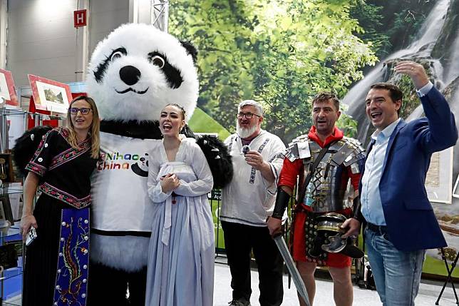 Visitors pose for photos with a giant panda mascot of China's stand at the autumn edition of Romania's Tourism Fair in Bucharest, Romania, Nov. 22, 2024. China's stand attracted visitors at Romania's Tourism Fair, which is held here from Nov. 21-24, as China has expanded its visa-free policy to nine additional countries. (Photo by Cristian Cristel/Xinhua)