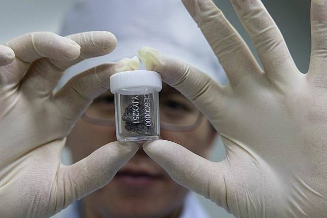 A researcher shows a lunar sample retrieved by the Chang'e-6 mission at the lunar sample laboratory in the National Astronomical Observatories of the Chinese Academy of Sciences (CAS) in Beijing, capital of China, Sept. 24, 2024. (Xinhua/Jin Liwang)