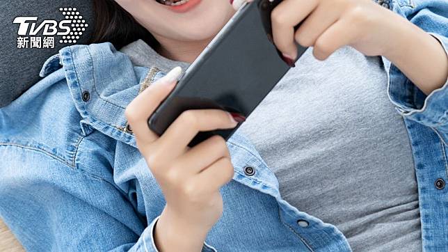 中國大陸女子躺著滑手機不慎砸斷牙齒。（示意圖／Shutterstock達志影像）