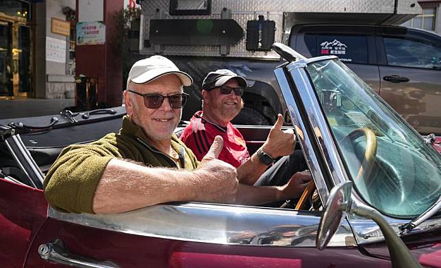 Michael Henry Johnston (L) and Paul John Rowland (both from the UK) pose for a photo in their car in Lhasa, southwest China's Xizang Autonomous Region, May 17, 2024.(Xinhua/Jigme Dorje)