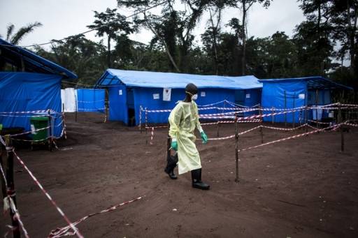AFP PHOTO / JOHN WESSELS ภาพนี้ถูกถ่ายระหว่างการระบาดของไวรัสอีโบล่าเมื่อปีีที่แล้วในคองโก ในขณะที่เจ้าหน้าที่สาธารณสุขกำลังตรวจตราพื้นที่ติดเชื้อในหมูบ้านมูมา