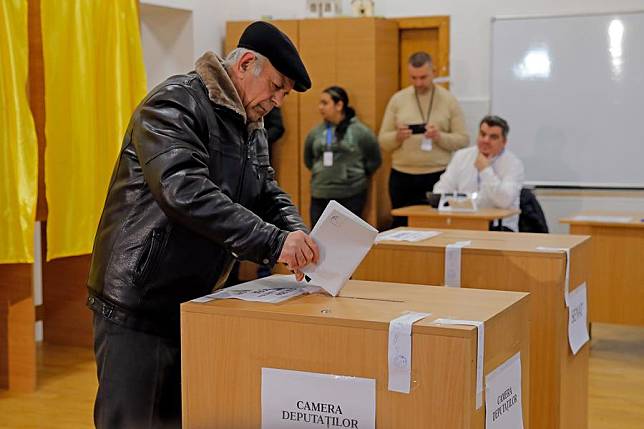 A man votes at a polling station in Mogosoaia, near Bucharest, Romania, Dec. 1, 2024. More than 18 million Romanian citizens, including those living abroad, cast ballots to fill 332 seats in the Chamber of Deputies and 137 in the Senate. (Photo by Cristian Cristel/Xinhua)